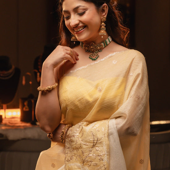 Woman in a yellow saree with a blurred background
